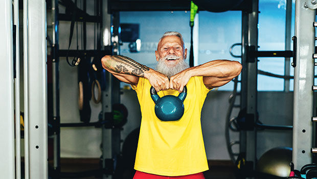 man smiling with a kettlebell
