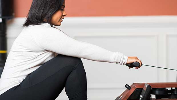 woman using a rowing machine at home