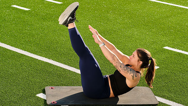 woman performing lying toe touch exercise