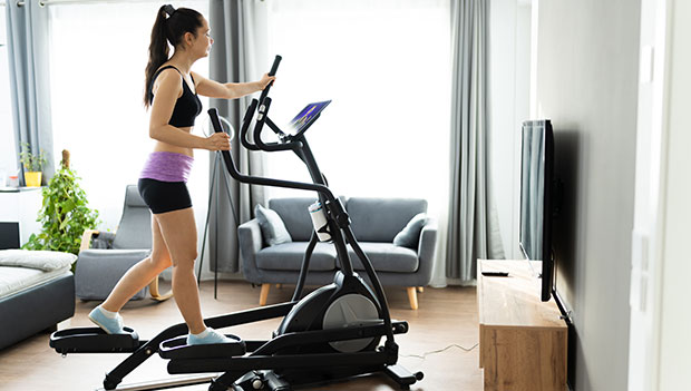 woman using an elliptical in home gym
