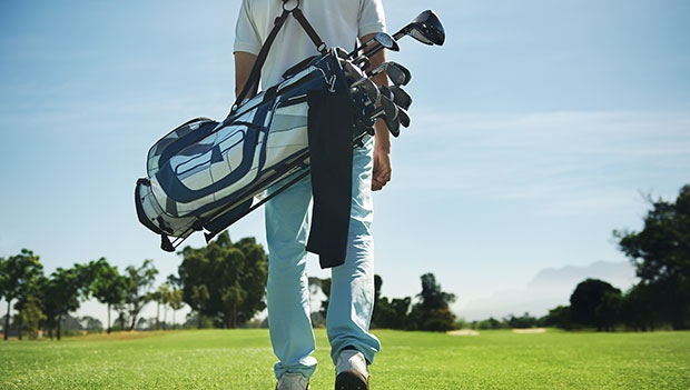golfer walking on course with golf bag