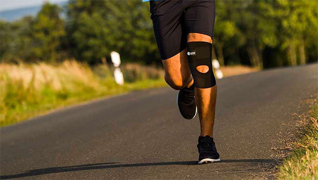 man-running-on-a-road-while-wearing-a-knee-brace