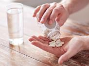 man-holding-a-pillbottle-and-pill-capsules