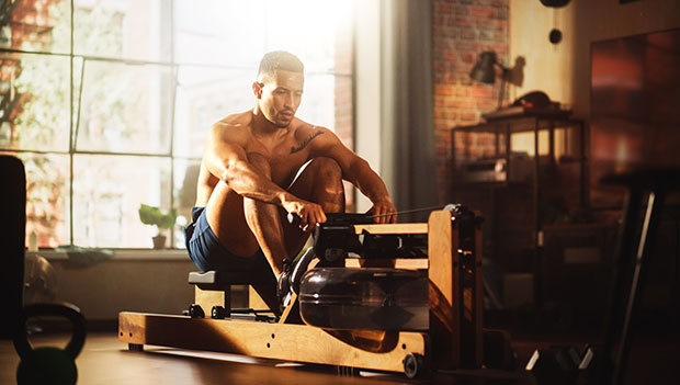 man using a water rower