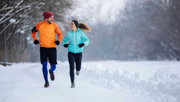 man and woman running in snow