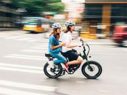 couple-riding-an-electric-bike-in-a-city