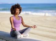 athletic-woman-meditating-on-a-beach
