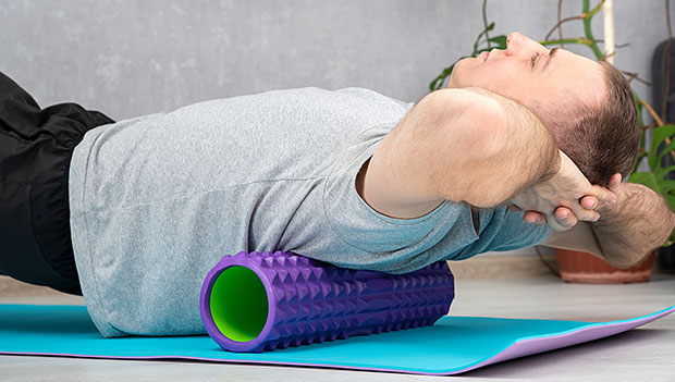 person using foam roller on back