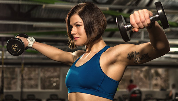 woman performing side lateral raise with dumbbells