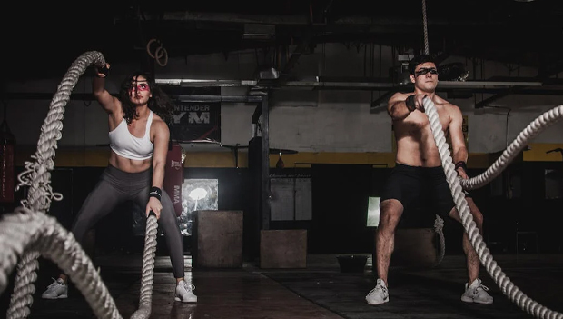 Couple doing crossfit with battle ropes