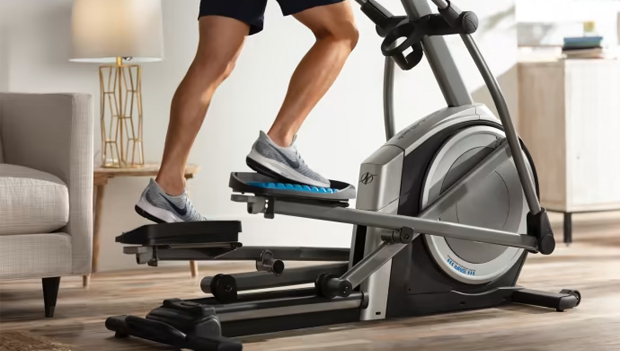 man using elliptical with incline
