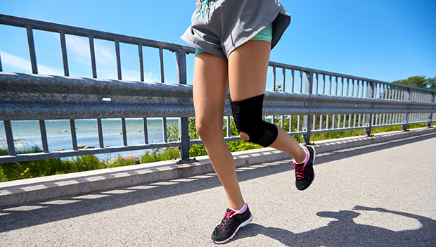 woman wearing a knee sleeve while running