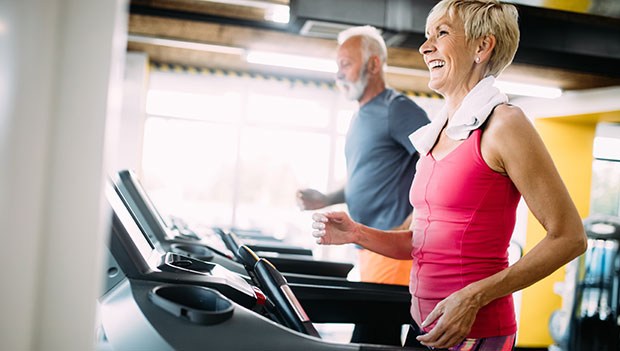 two older people on treadmills