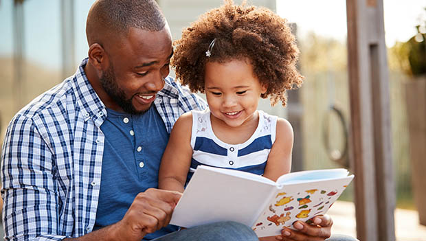 father and daughter reading a book