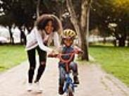 mother teaching son to ride a bike-front