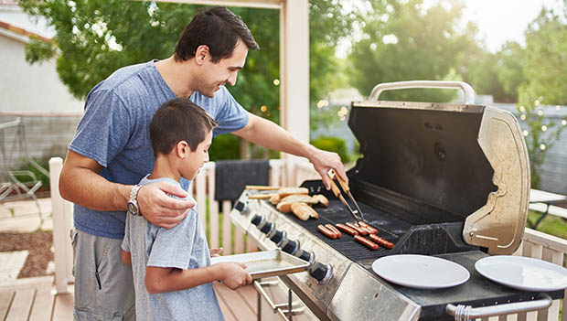 father and son at the grill