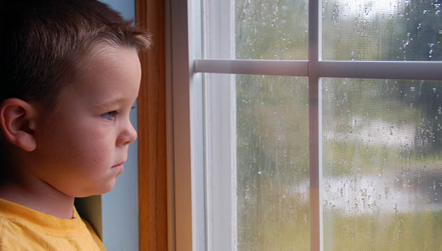 kid at a rainy window