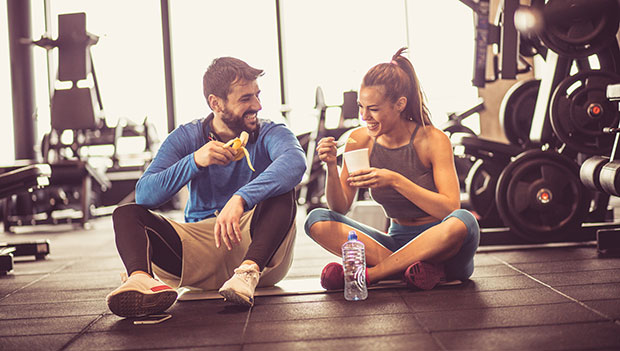 man and woman eating in gym