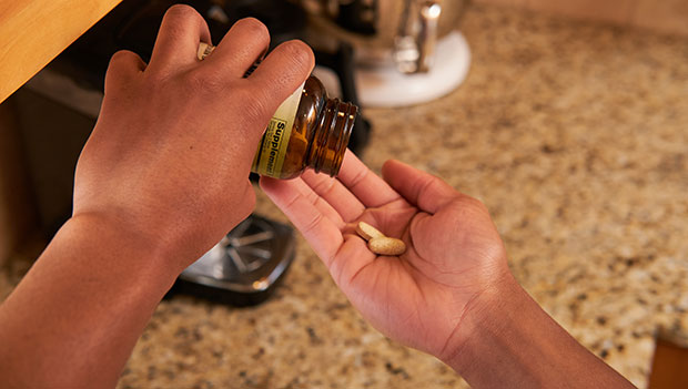 man pouring pills into hand