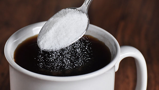 spooning sugar into coffee