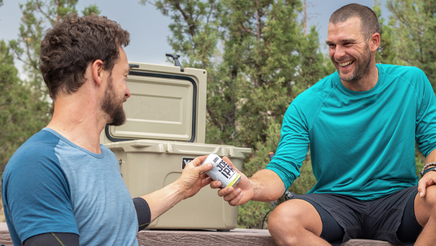 men sharing a drink with a cooler